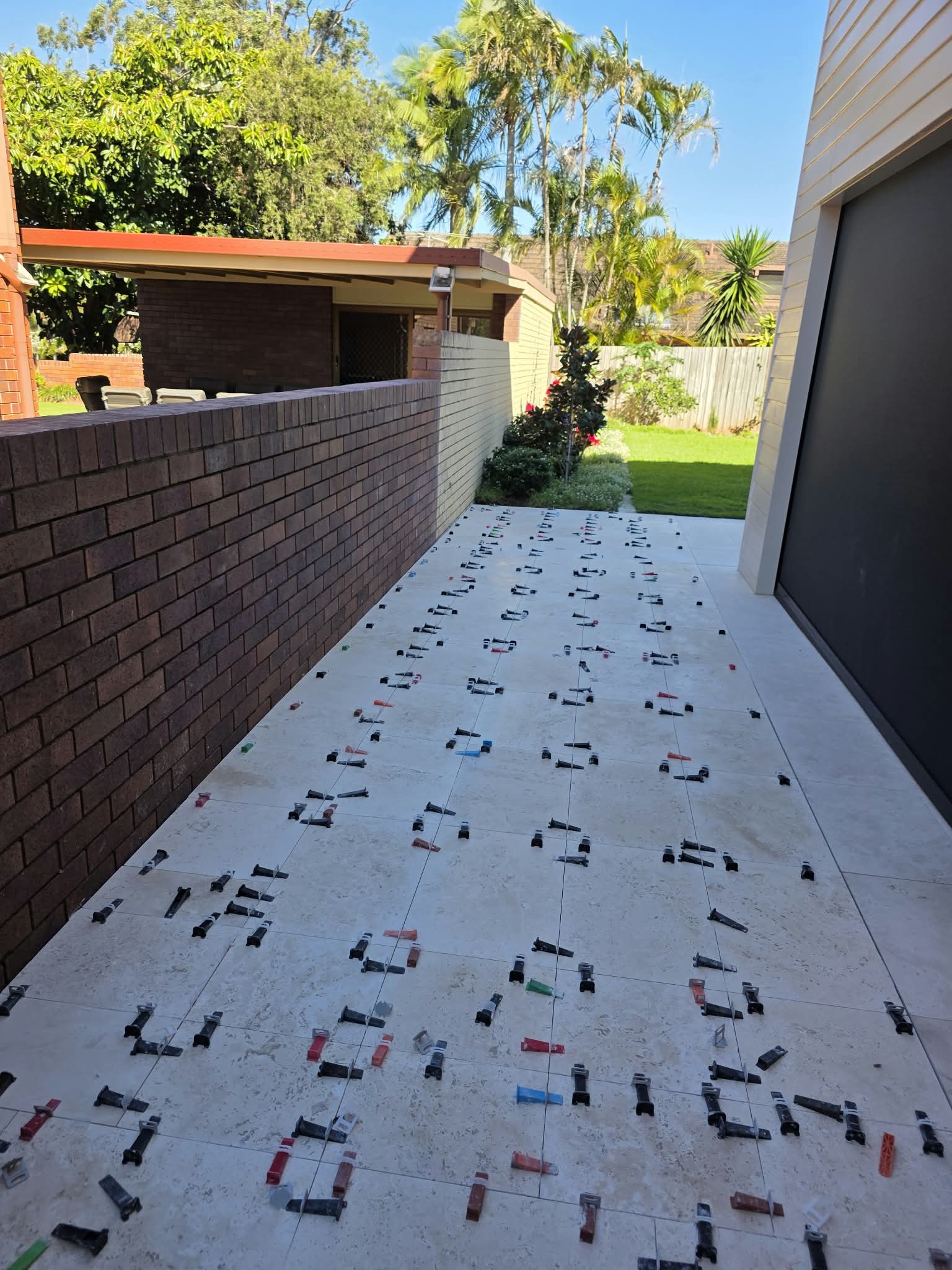 Outdoor alfresco tiling in progress with levelling clips
