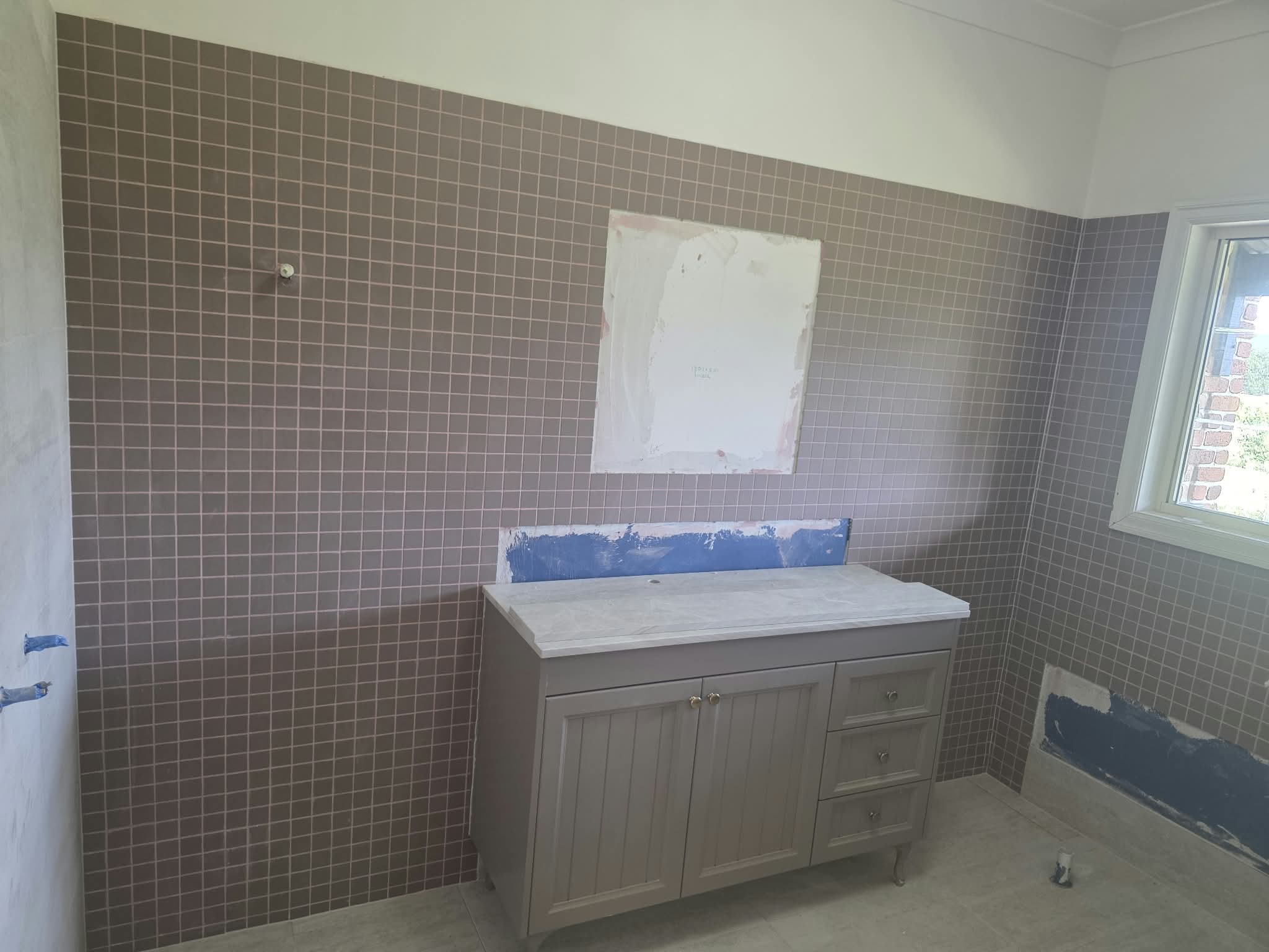 Bathroom renovation with mauve mosaic tile and vanity
