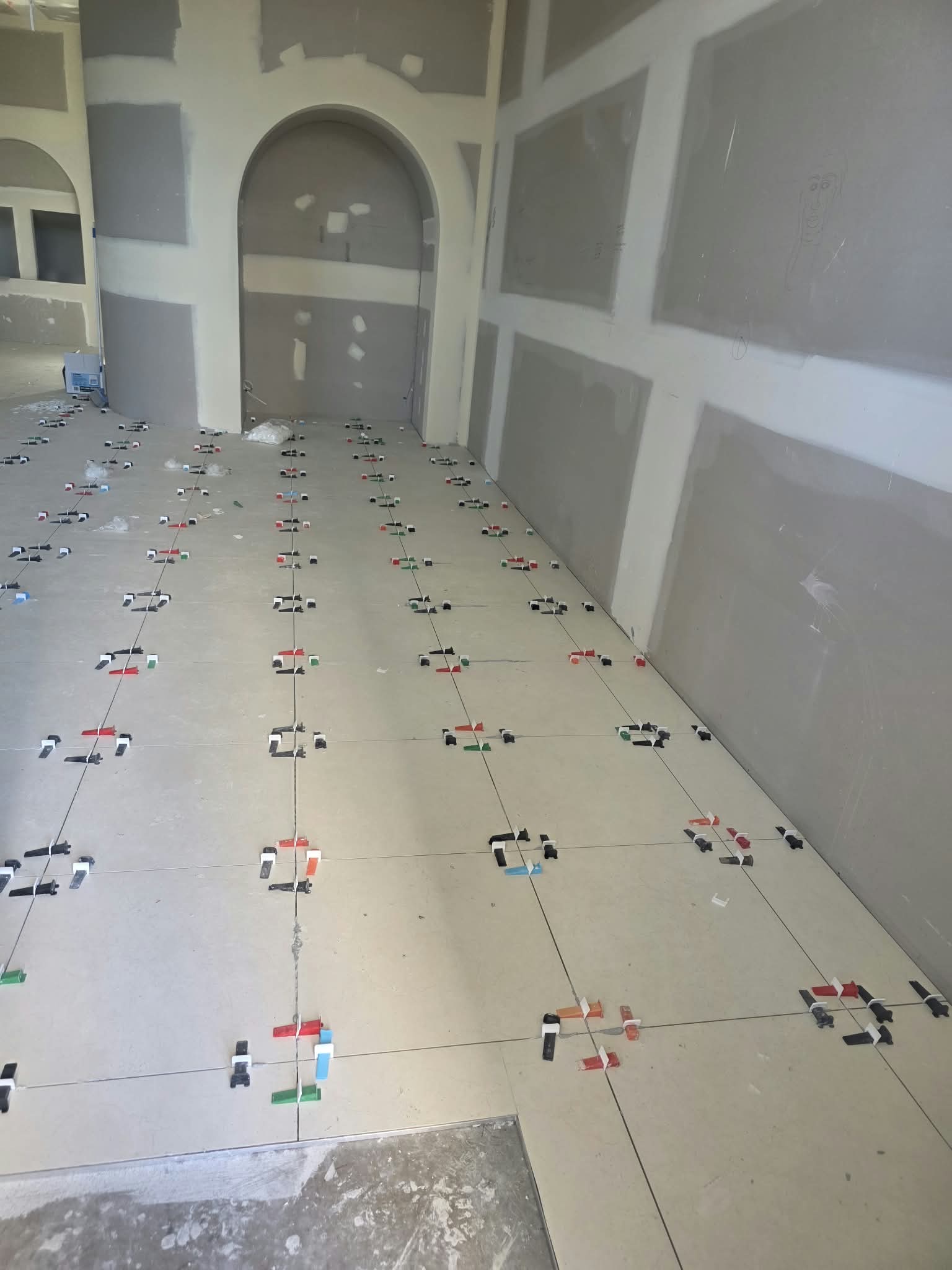 Large-format floor tiling in progress with levelling spacers