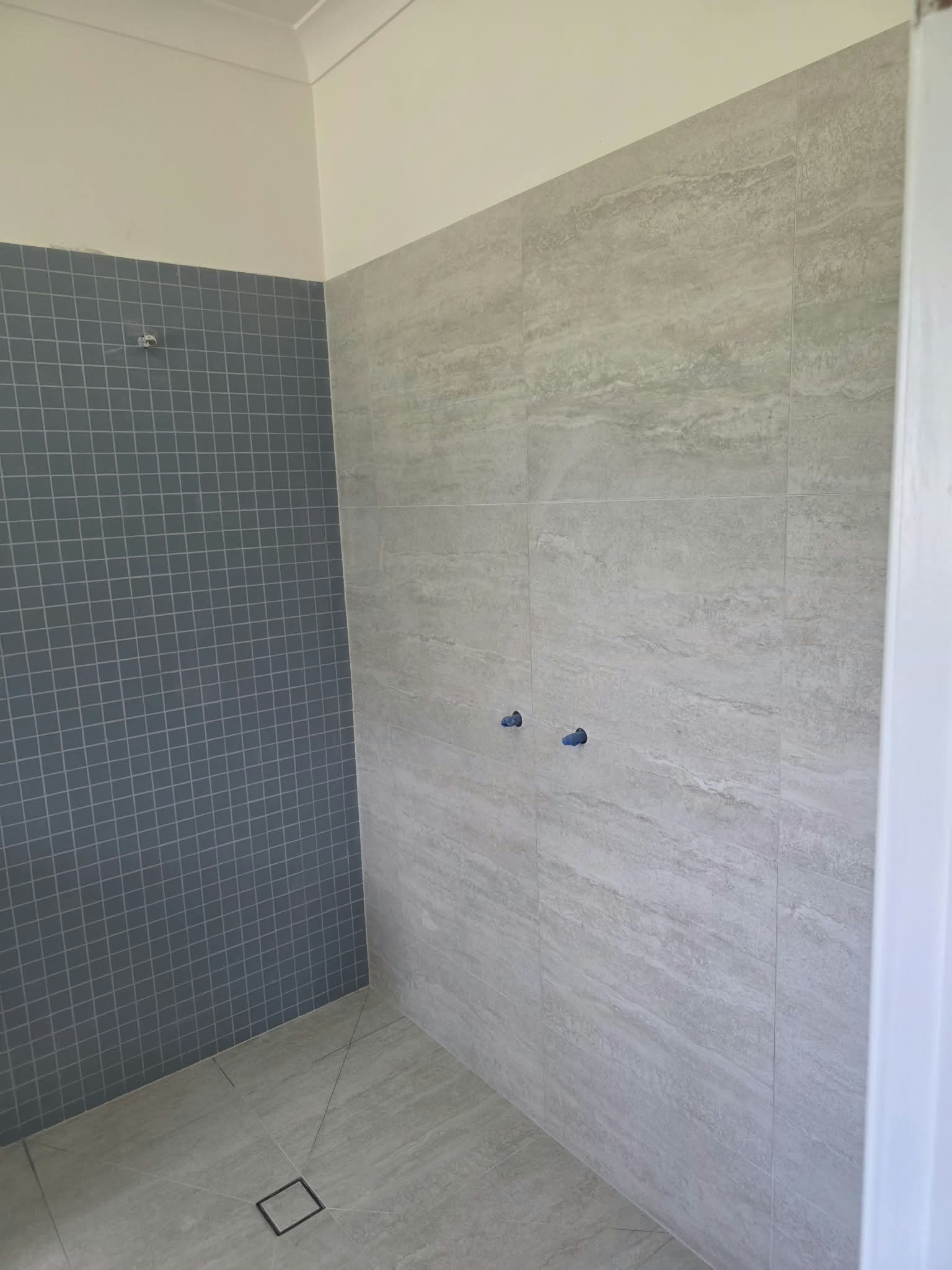 Freshly tiled shower with waterproofed drain, ready for grouting